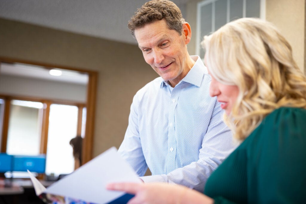 An orthodontist reviews paperwork with a woman.