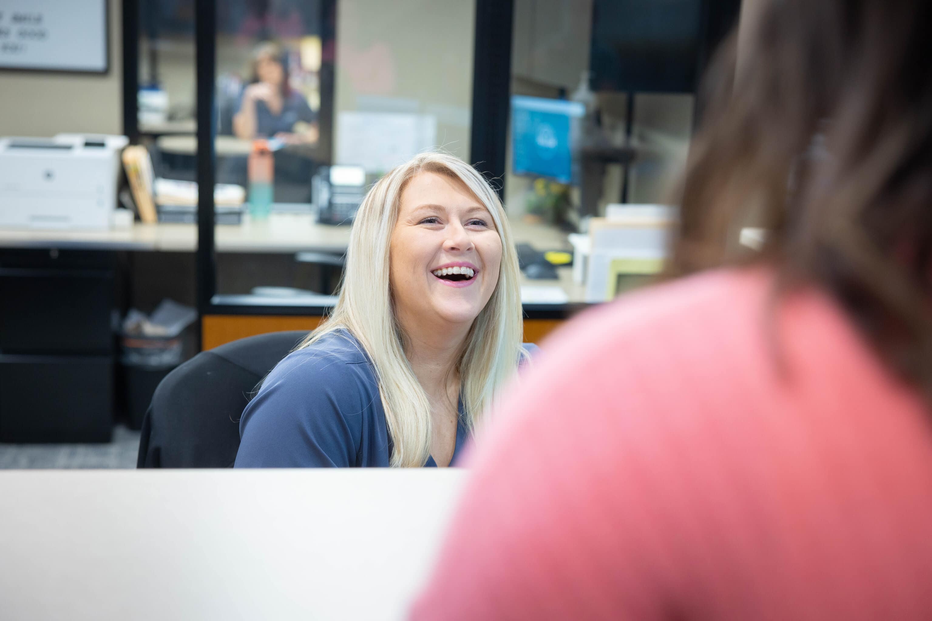 Orthodontic team member smiling at reception desk