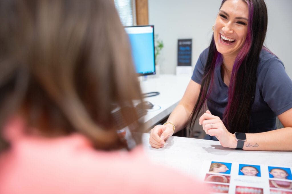 Orthodontic team member reviews patient photos at desk